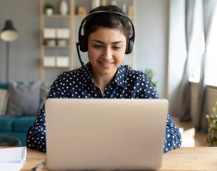 Smiling,Millennial,Indian,Girl,In,Wireless,Headset,Sit,At,Desk